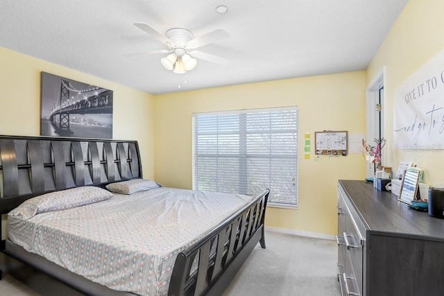 bedroom featuring ceiling fan, baseboards, and light colored carpet