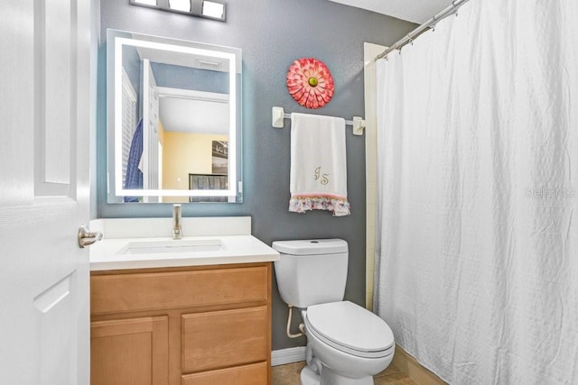 bathroom featuring curtained shower, vanity, and toilet