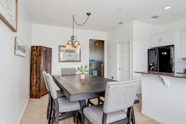 dining space featuring baseboards, visible vents, a notable chandelier, and light tile patterned flooring