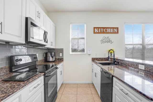 kitchen featuring white cabinets, decorative backsplash, black appliances, a sink, and light tile patterned flooring