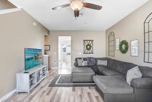 living room with light wood finished floors, ceiling fan, visible vents, and baseboards