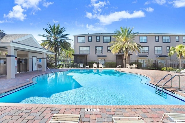 community pool featuring fence and a patio