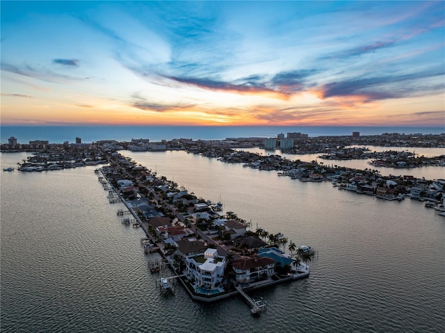 aerial view at dusk featuring a water view