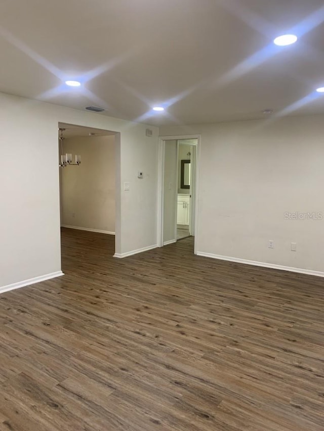 empty room with recessed lighting, dark wood-style flooring, visible vents, and baseboards