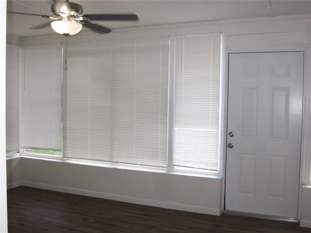 interior space with dark wood finished floors, a ceiling fan, and baseboards