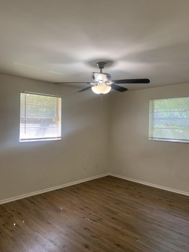 unfurnished room featuring plenty of natural light, baseboards, and wood finished floors