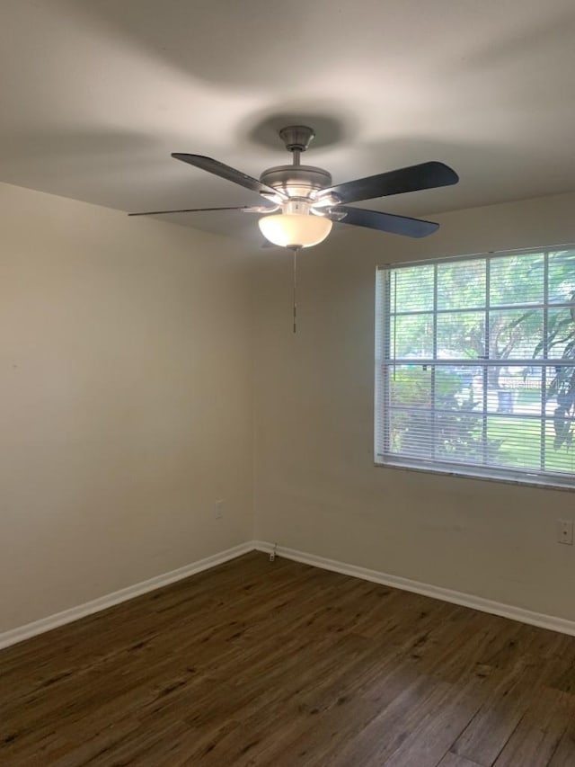 spare room with dark wood-style floors and baseboards