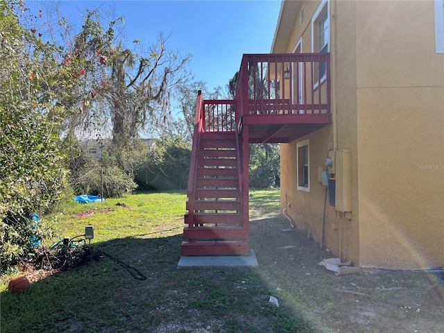 view of playground featuring a yard, stairway, and a wooden deck