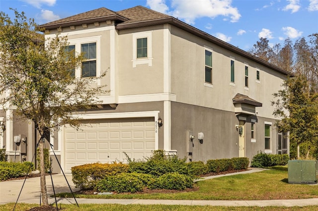 view of front of house with stucco siding, an attached garage, and driveway