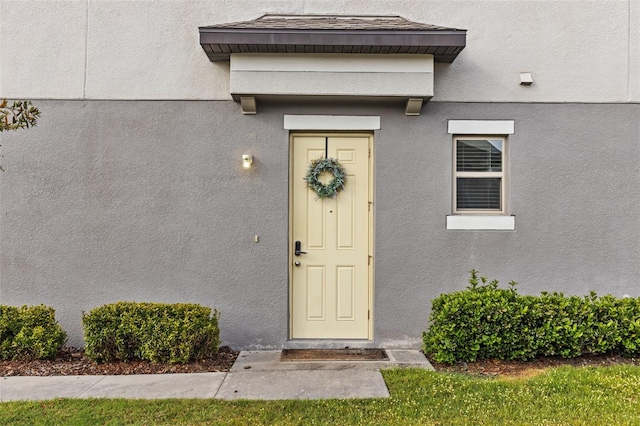 view of exterior entry featuring stucco siding