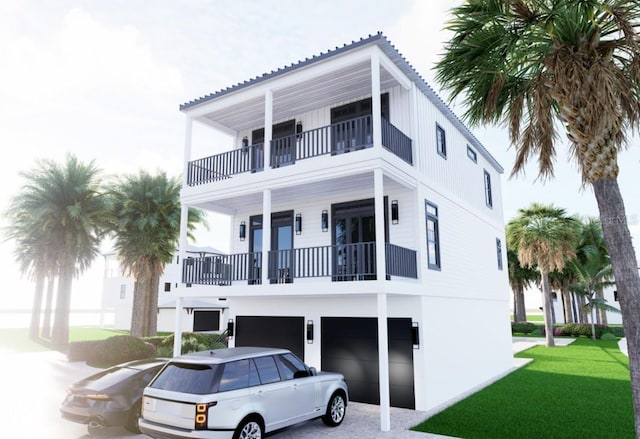 raised beach house featuring a balcony, an attached garage, and a front yard