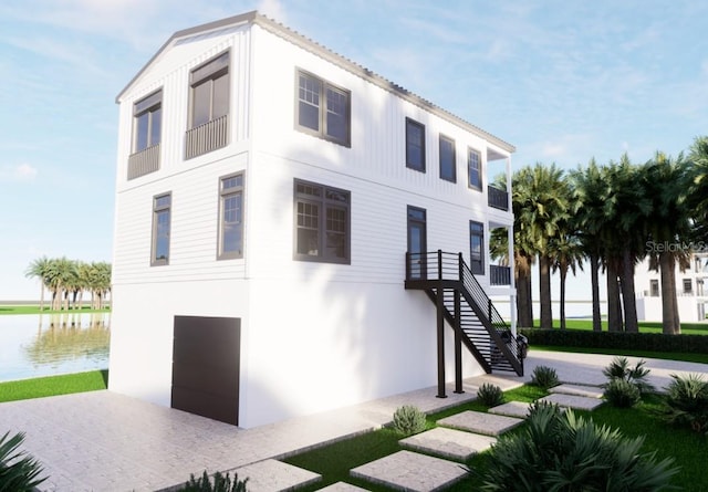 view of front of home featuring a water view, stairs, and stucco siding