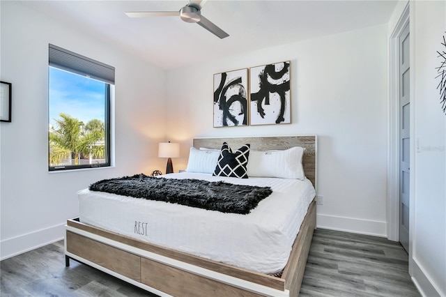 bedroom with ceiling fan, baseboards, and wood finished floors