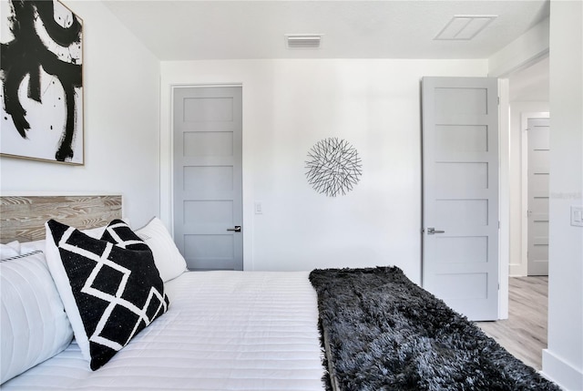 bedroom featuring visible vents and wood finished floors