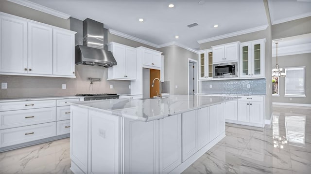 kitchen featuring marble finish floor, stainless steel appliances, visible vents, a sink, and wall chimney exhaust hood