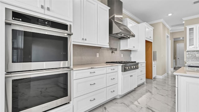 kitchen with wall chimney exhaust hood, appliances with stainless steel finishes, marble finish floor, light countertops, and crown molding