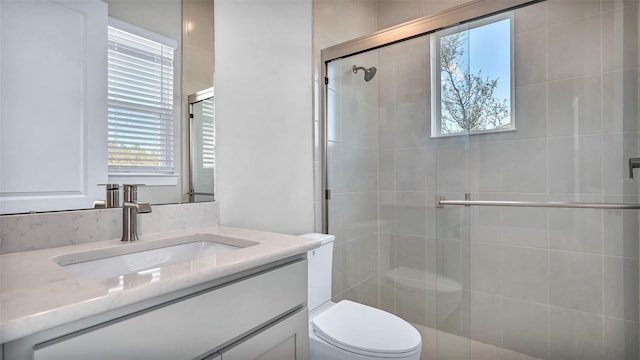 bathroom featuring a stall shower, vanity, and toilet