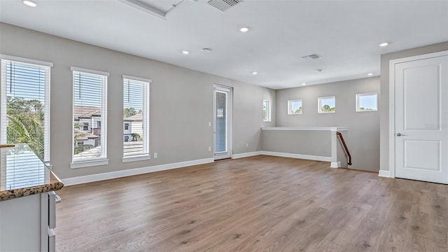 unfurnished room with light wood finished floors, baseboards, a wealth of natural light, and recessed lighting