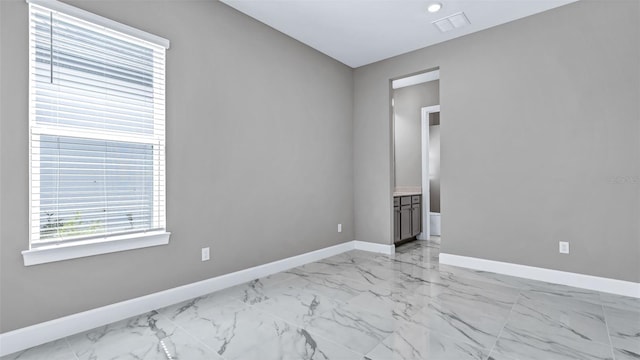 spare room with marble finish floor, visible vents, and baseboards