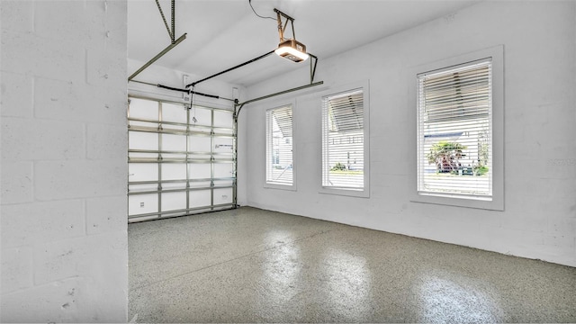 garage with concrete block wall and a garage door opener