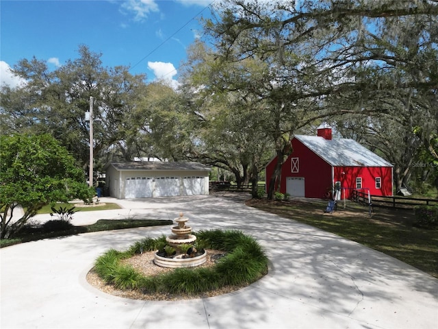 exterior space with a detached garage, fence, and an outdoor structure