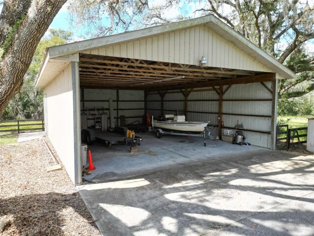 exterior space with driveway, a detached carport, and an outbuilding