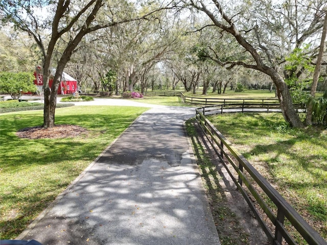 view of property's community featuring a yard and fence