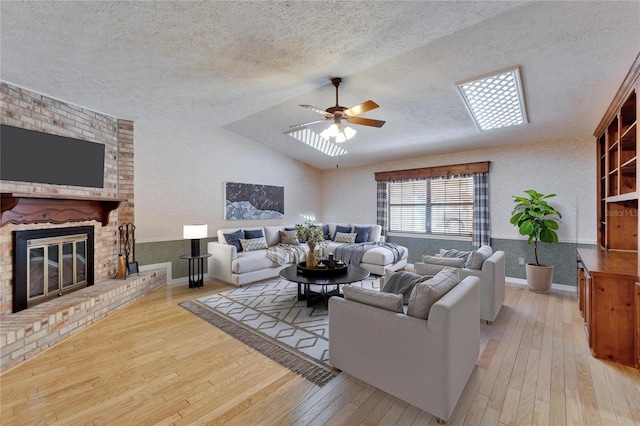 living room with lofted ceiling, wood-type flooring, a fireplace, and a textured ceiling