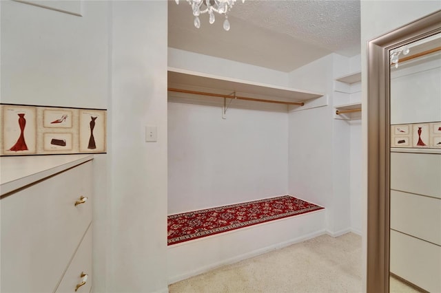 walk in closet with carpet floors and an inviting chandelier