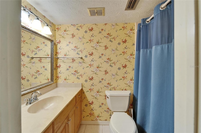 bathroom with wallpapered walls, visible vents, tile patterned floors, a textured ceiling, and vanity