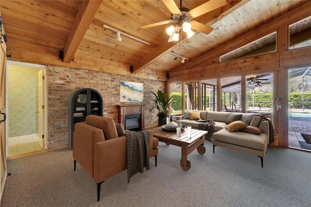 carpeted living room with a ceiling fan, a glass covered fireplace, wooden ceiling, vaulted ceiling with beams, and rail lighting