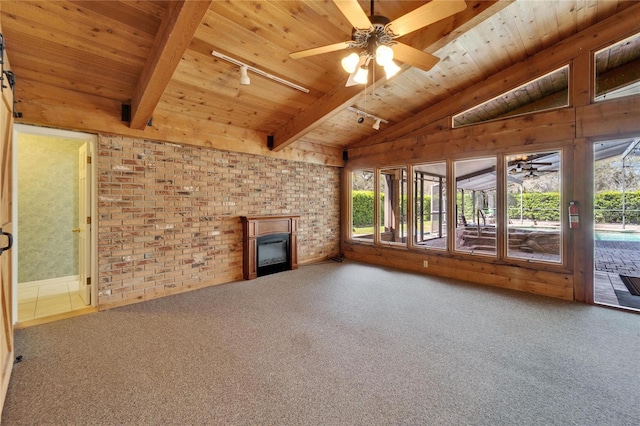 unfurnished living room featuring wood ceiling, vaulted ceiling with beams, rail lighting, carpet floors, and a fireplace