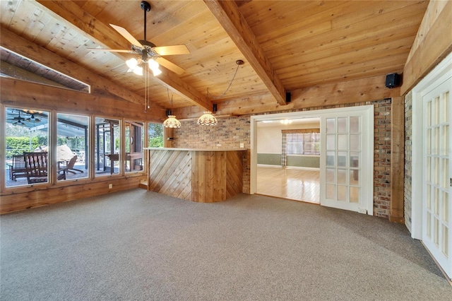 carpeted empty room with vaulted ceiling with beams, wood ceiling, a sunroom, ceiling fan, and wooden walls