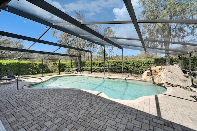 outdoor pool with glass enclosure and a patio