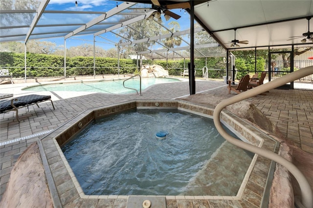 pool featuring a lanai, a patio area, ceiling fan, and an in ground hot tub