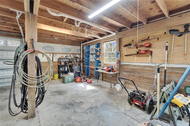 garage featuring a workshop area and wooden walls