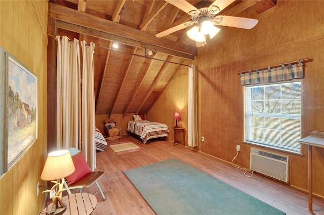 unfurnished bedroom with lofted ceiling, a ceiling fan, wood finished floors, and a wall mounted air conditioner