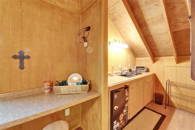 bathroom with vaulted ceiling with beams, wooden ceiling, wood walls, a sink, and wood finished floors