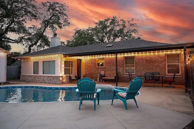 outdoor pool with a patio and fence