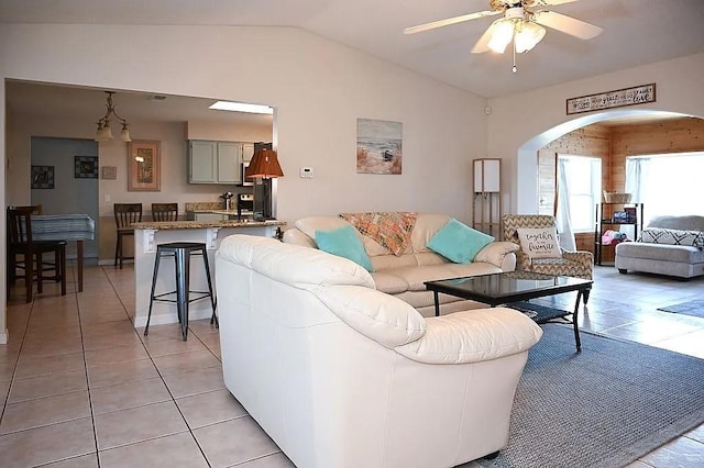 living area with ceiling fan, vaulted ceiling, and light tile patterned floors