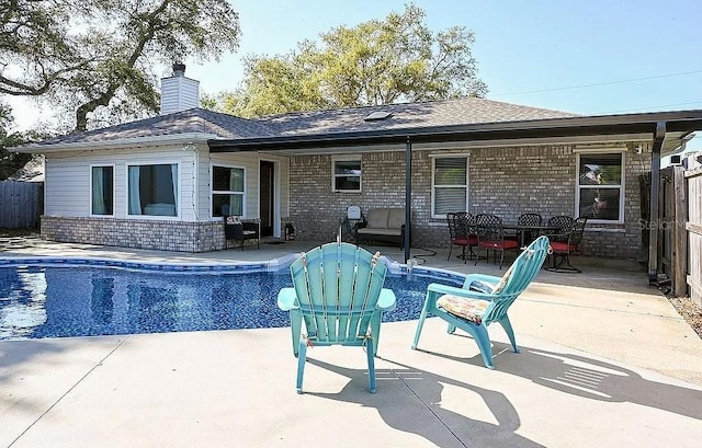 outdoor pool with a patio and fence