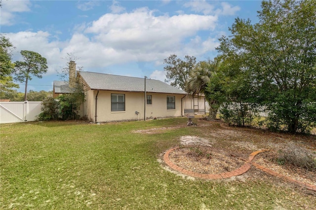 12172 SE 96th Ter, Belleview, FL 34420 - back of property featuring a gate, fence, a lawn, and stucco siding