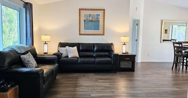 living room featuring lofted ceiling, dark wood-style floors, and baseboards