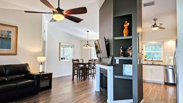 kitchen with ceiling fan with notable chandelier, wood finished floors, a sink, visible vents, and dishwasher