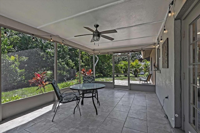 unfurnished sunroom with ceiling fan