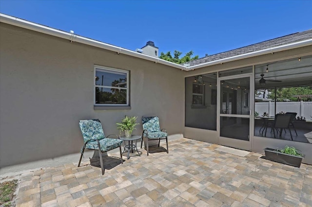 view of patio with a sunroom and fence