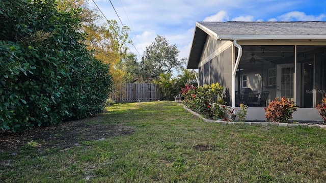 view of yard with fence and a sunroom