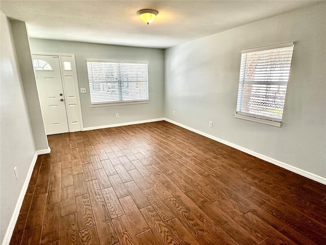 foyer entrance featuring dark wood-style flooring and baseboards