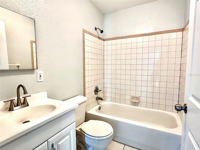 full bath with a textured wall, toilet, tile patterned flooring, vanity, and washtub / shower combination