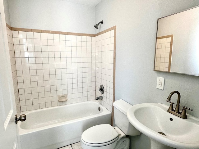 full bathroom featuring washtub / shower combination, tile patterned flooring, a sink, and toilet